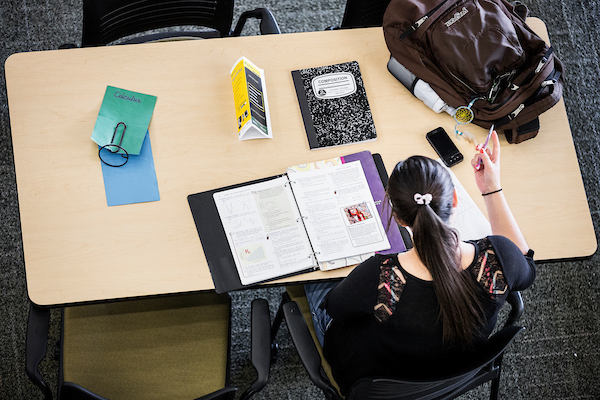 Aerial view of student sitting at a table doing classwork